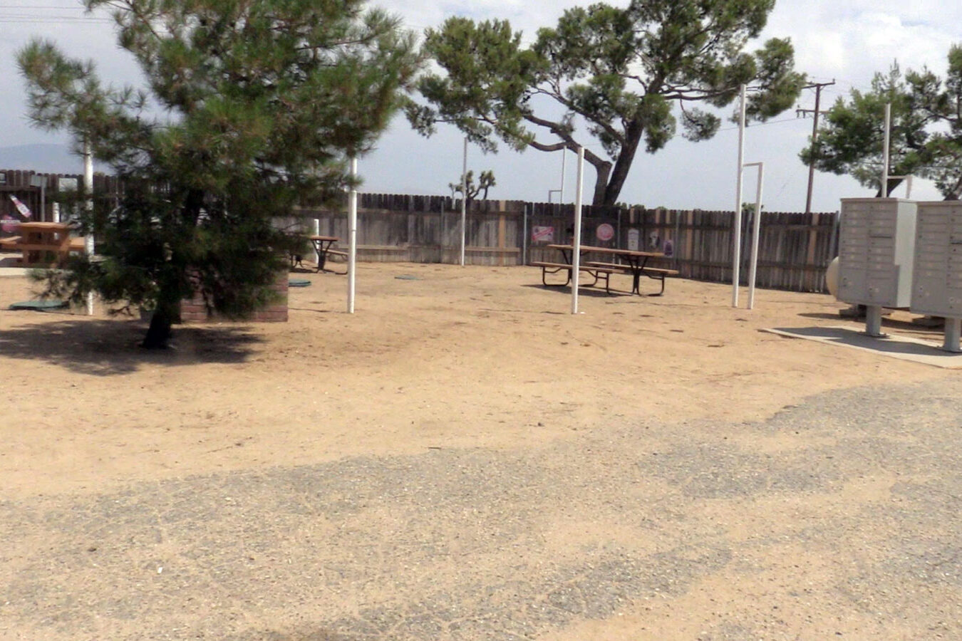 Dirt lot with picnic tables and PO Boxes.
