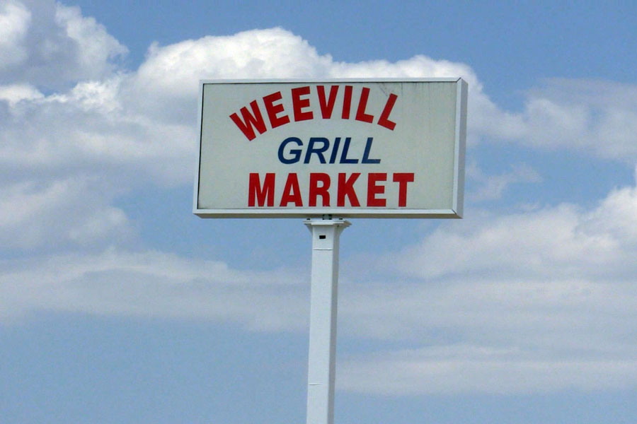 Wee Vill Market sign with the sky background.