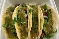 Four taco in a to go box.